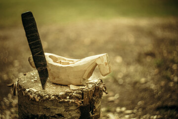 Cutting mugs out of wood. A knife and a wooden blank for making a bowl.