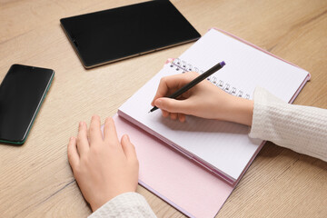 Children's hand writes in a notebook