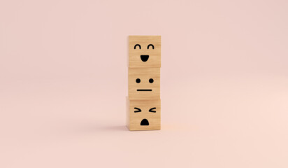 Happy face smile or sad and anger wooden cube on pink paper background.