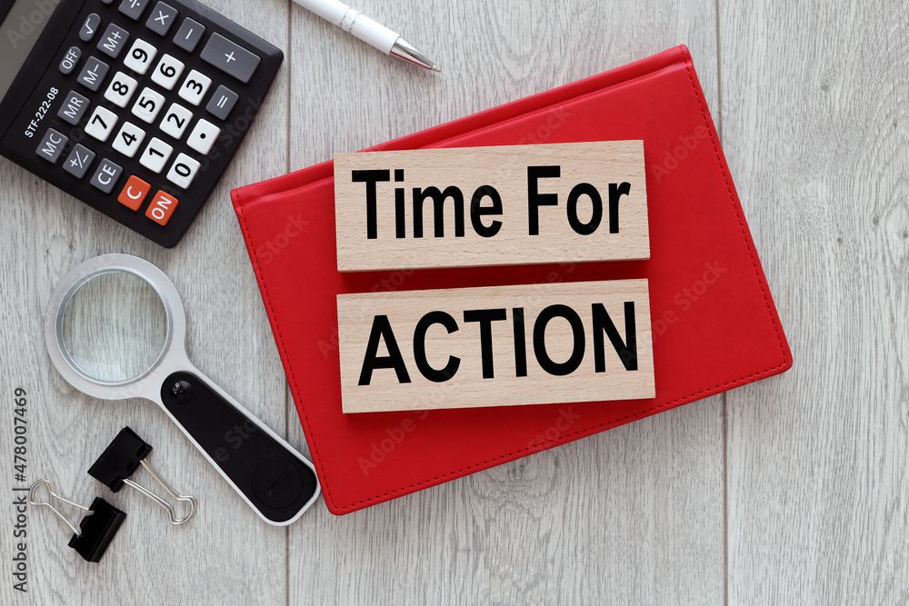 Poster time for action. two wooden blocks on a wooden background. on red open notebook business concept