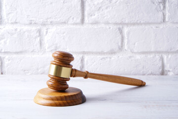 Judge gavel close up on white brick wall background