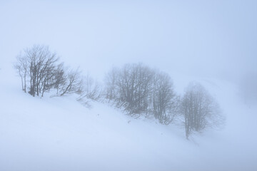 panorama sulle colline e i monti innevati di campo staffi, tra lazio e abruzzo, avvolti da una fitta nebbia