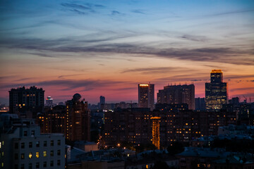 Naklejka premium Red an blue sunset or sunrise with clouds and buildings silhouette in the city. Moscow.