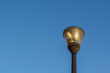 Fototapeta na wymiar Street lantern, electric lighting. Lamp on background of blue sky.