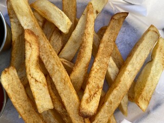 Close up on potato chips (thick cut French fries) fresh from a deep fryer