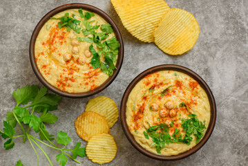 Classic hummus with parsley close-up, chips, top view