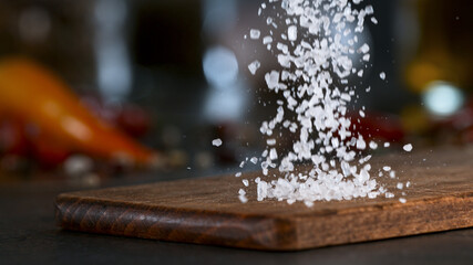 Freeze Motion Shot of Falling Coarse-Grained Salt. Kitchen background.