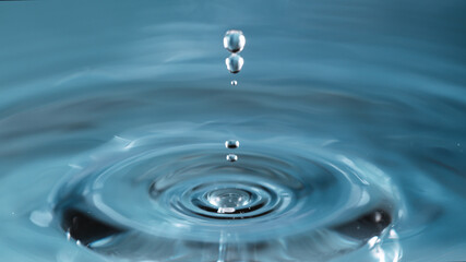Naklejka na ściany i meble Water splash isolated on light blue background, macro shot.