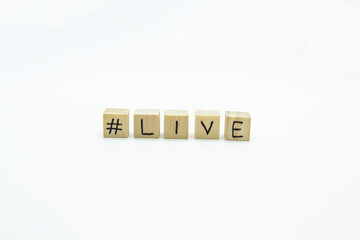 Word LIVE written on the wood cubes on white  background. The concept photo with letters #live