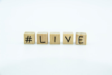 Word LIVE written on the wood cubes on white  background. The concept photo with letters #live