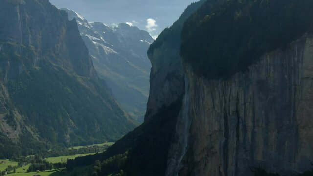 Aerial drone over the village of Lauterbrunnen and Staubbach Falls waterfall in Switzerland on a sunny day during summer 