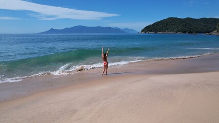 Brazilian woman in bikini on a deserted beach in Ubatuba, São Paulo, Brazil.
Atlantic forest, yellow sand and clear sea water. Figueira beach paradise.