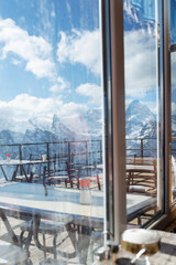 Magnificent view from the window of the cafe on the snowy mountains in the ski resort. Active lifestyle and sports. Vertical.