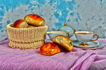 HDR photo of coffee in vintage cup, raisin buns on table and in basket.
