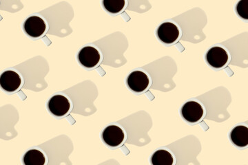 Black coffee in ceramic cups on beige background. Top view. Seamless repeating pattern.