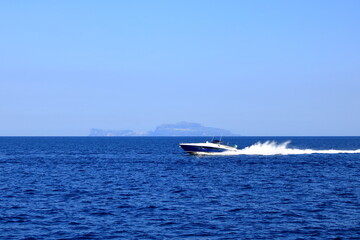 Fototapeta premium Silhouette of Capri island from a distance with famous Faraglioni rocks