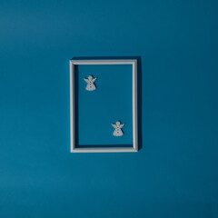 White guardian angels of joy and happiness in a white frame on a blue background