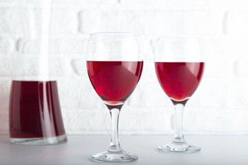 Closeup detail view of bowls of red wine and carafe, over white backdrop