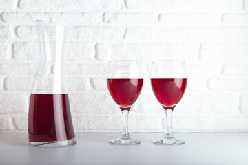 Closeup detail view of bowls of red wine and carafe, over white backdrop