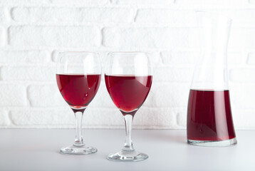 Closeup detail view of bowls of red wine and carafe, over white backdrop