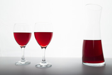 Closeup detail view of bowls of red wine and carafe, backlit illuminated with reverse light includes copy space.