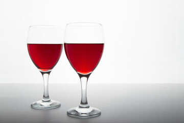 Closeup detail view of bowls of red wine, backlit illuminated with reverse light includes copy space.