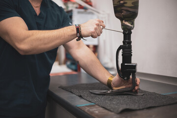 an orthopedist fixes a leg prosthesis for a patient.