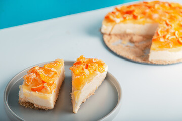 Closeup detail view sliced orange cheesecake or pudding, decorated with riped orange fruit.