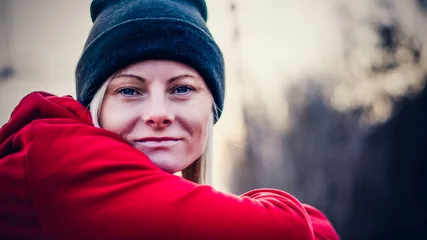 Tuinposter Zimowy portret kobiety w czapce i czerwonej bluzie © Karolina