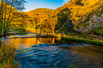 A long exposure view at sunset of the River Dove valley at Dovedale, UK on a sunny Autumn evening