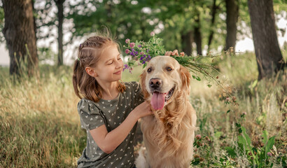 Preteen girl with golden retriever outdoors