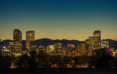 Obraz premium Illuminated Denver Downtown Towers and Front Range Mountains in a Background