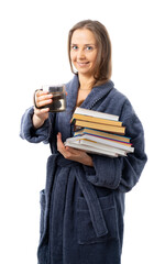 A woman in a bathrobe holds a lot of books and a mug of water. drink a lot and stay at home - the key to health. relaxes with an interesting book. Self isolation. coronavirus, flu, epidemic. isolated.
