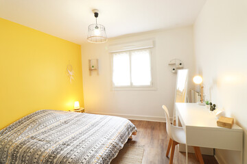 Room with yellow wall, bohemian spirit. A white desk and white chair