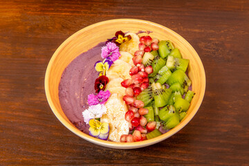 Healthy bowl of yogurt with fruits, ripe kiwis, bananas and pomegranate grains