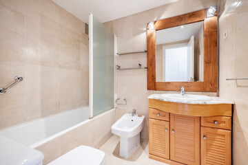 Full bathroom with cherry-colored furniture and square wood-framed mirror