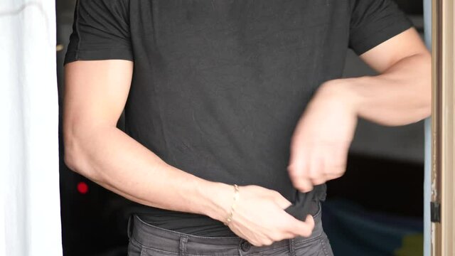 Young fit man opening shirt on naked muscular torso