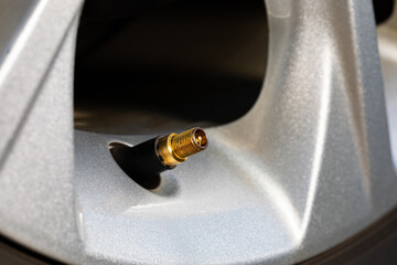 Tire valve stem on car wheel. Vehicle safety, tire wear, fuel mileage and winter checkup concept. 