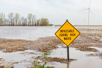 Road closed sign and high water flooding roadway. Storm and rain damage, weather warning and...