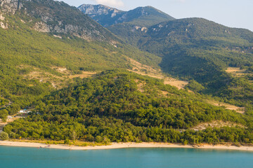 The Lake of Sainte-Croix and its green banks in Europe, in France, Provence Alpes Cote dAzur, in the Var, in summer, on a sunny day.