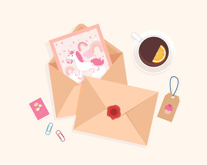 Top view of desk with envelopes, post card, post stamps and cup of tea