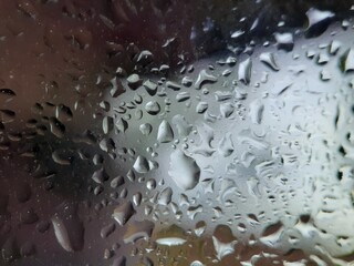 Macro of water droplets on glass with defocused background