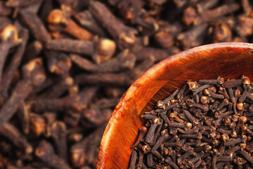 Cloves in brown wooden bowl isolated. Empty copy space for text design white background. Kitchen...