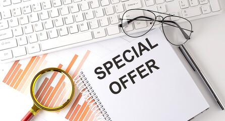 SPECIAL OFFER text written on a notebook with keyboard, chart,and glasses