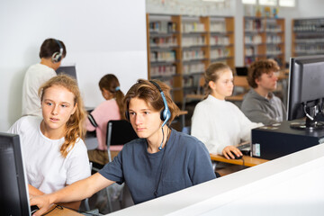 Teenage student in headphones at the computer in a school class