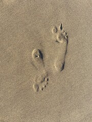 footprints on the sand, two foot mark opposite direction on a sandy beach from the top