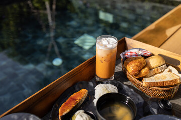 Full set breakfast set in tray at pool hotel. Concept for food and vacation at hotel.