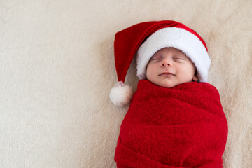 Top View Portrait First Days Life Newborn Cute Funny Sleeping Baby In Santa Hat Wrapped In Red Diaper At White Garland Background. Merry Christmas, Happy New Year, Infant, Childhood, Winter Copy space