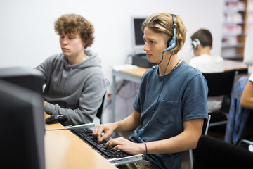 Schoolboy and schoolgirl working with computers in classroom