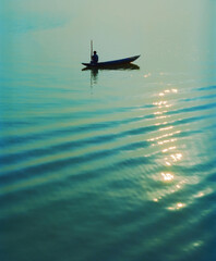 Silhouette of Vietnamese fisherman in traditional sampan fishing boat © Cameo